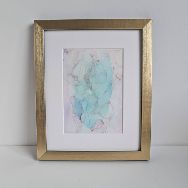 Fluid abstract artwork in pastel aqua, purple, and pink tones, showcasing soft swirls, intricate patterns, and dynamic brushstrokes. In a white mount and gold frame.