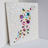 Abstract artwork featuring intricate hand-cut sequins, beads, and embroidery on canvas with a unique, multi-directional design.