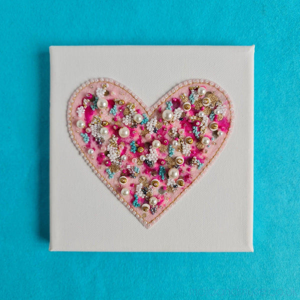 Abstract heart artwork with hand-embroidered metallic threads and beads on canvas, showcasing intricate craftsmanship.