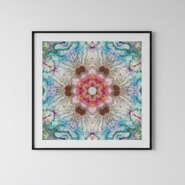Framed colorful mandala art on a white wall above a gray sofa.