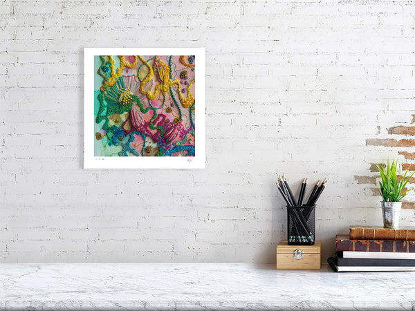 Viola Five 2022 vibrant abstract embroidery detail print framed on white wall above desk with books and pencils