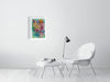 Viola Five 2022 abstract colorful giclée fine art print in white frame on gray wall above modern white chair and ottoman.