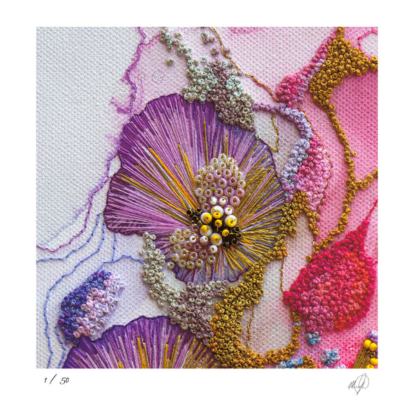 Close-up of hand-stitched Viola embroidery with rich textures and vibrant purples, pinks, and yellows on white fabric background