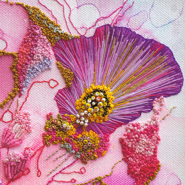 Close-up of hand-stitched Viola embroidery detail with vibrant purple, pink, and yellow threads and beadwork texture.