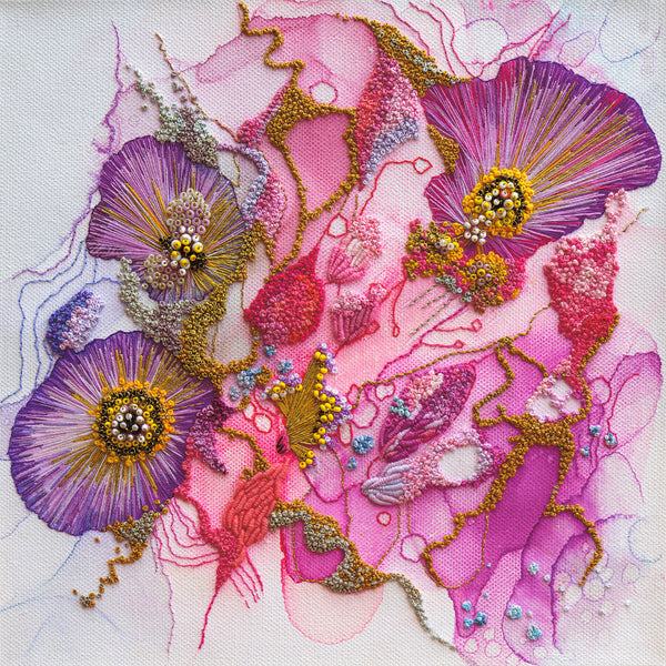 Abstract floral embroidery in vibrant purples, pinks, and golds with intricate texture on white fabric background.