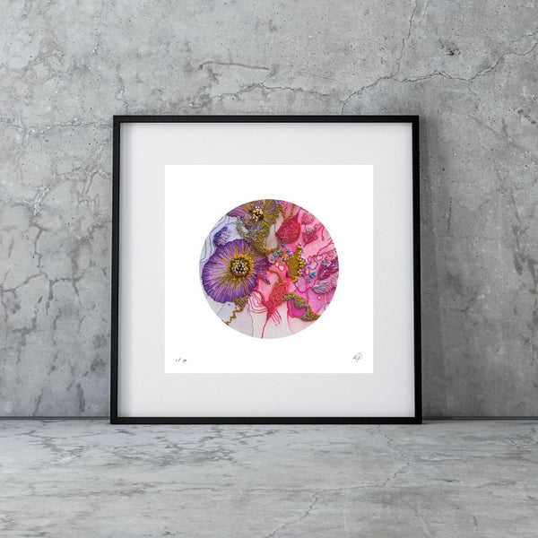 Framed abstract circular artwork by Manoela Grigorova with purple, gold, and pink shades leaning against a textured gray concrete wall.