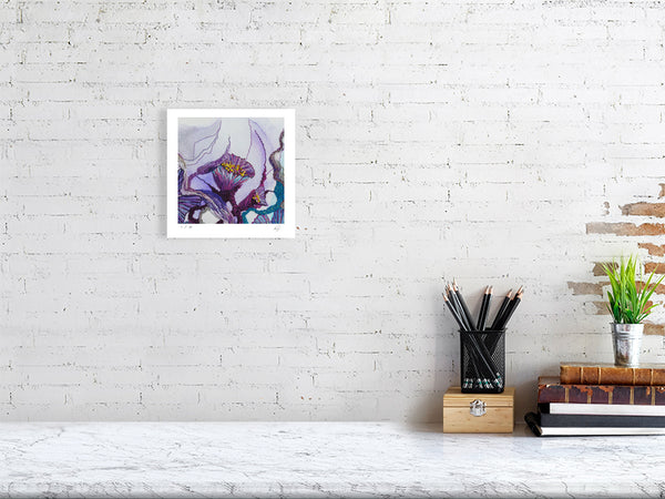 Framed Viola Seven 2023 fine art print with purple embroidery detail displayed on white brick wall above desk.