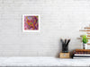 Viola Six 2022 Giclée fine art print showing colorful abstract embroidery detail on white brick wall above desk.