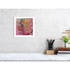 Abstract colorful Viola Six 2022 fine art print on white wall above a desk with pencils, books, and a plant.