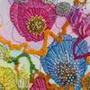 Close-up of colorful hand-stitched embroidery with beads and textured thread on a fine art print.