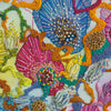 Close-up of vibrant hand-stitched embroidery with colorful threads, beads, and textured abstract floral patterns.