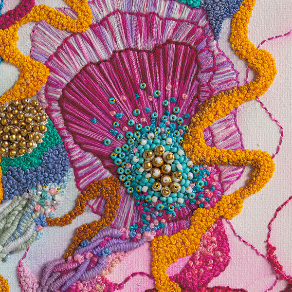 Close-up of Viola Three embroidery detail in vibrant pink, yellow, blue threads with intricate beadwork texture.