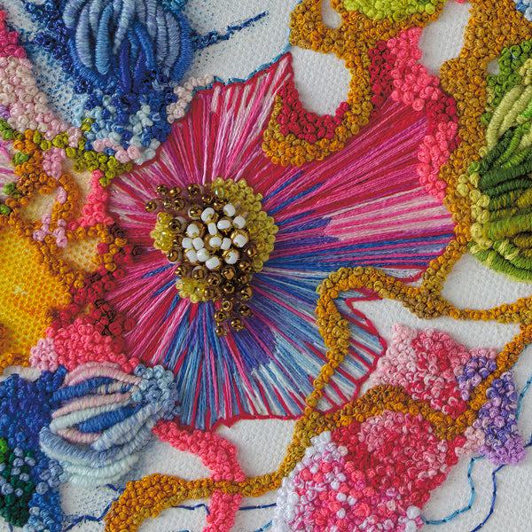Close-up of intricate, colorful hand-stitched embroidery showing detailed threads and beadwork from Viola Two 2021 print.