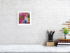 Viola Two 2021 Giclée fine art print featuring vibrant abstract embroidered details in a white frame on white brick wall