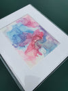 Abstract alcohol ink artwork titled Aphrodite Plays with flowing blue, pink, and purple hues on Yupo paper, mounted and sealed.
