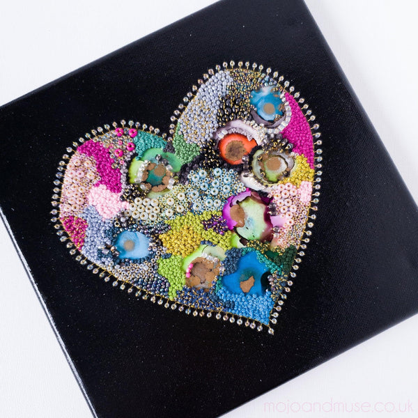 Black heart artwork on black canvas with colorful beads, embroidery thread, and alcohol ink, part of Heart Series 2021