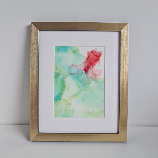 Abstract alcohol ink artwork titled Chloris Two 2018 with soft green and red hues on Yupo paper in gold frame