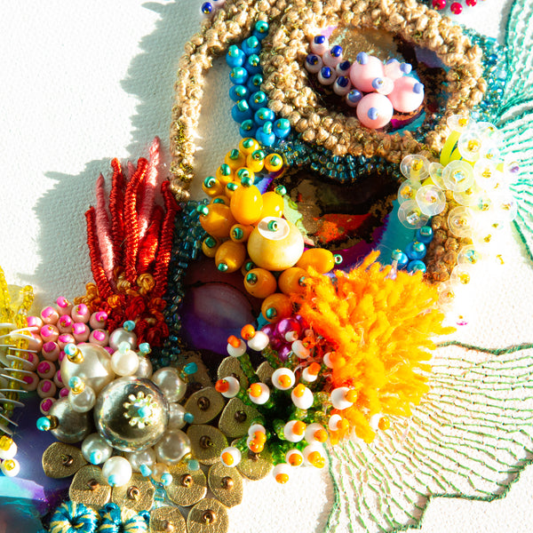 Close-up of Coral Wreath Nine with colorful beads, embroidery, metallic thread, and textured sea life elements on canvas.