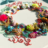 Abstract coral reef inspired wreath with beads, embroidery, faux flowers, and metallic thread on square canvas.