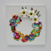 Abstract coral reef-inspired wreath artwork with white flowers, beads, embroidery, and vibrant colors on canvas.