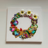 Abstract coral reef wreath collage with plumeria flowers, embroidery, beads, and gold thread on 30cm square canvas