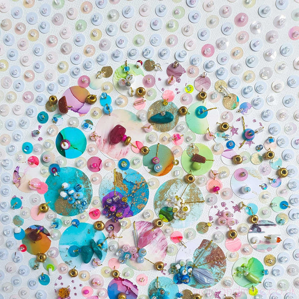 Upcycled beads and painted sequins embroidered on canvas in a colorful, abstract circular art piece.