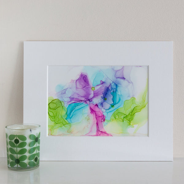 Abstract alcohol ink artwork titled Eostre 2018 with vibrant purple, blue, and green hues on Yupo paper in white mount.