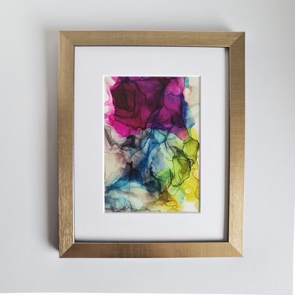 Abstract alcohol ink painting "Hera, 2018" with vibrant purple, blue, green, and yellow hues in a gold frame.