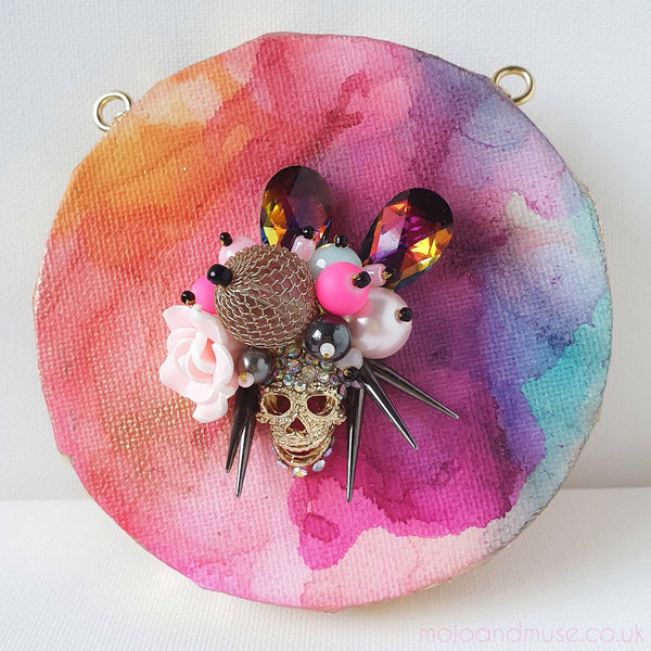 Features vibrant embroidery with beads, gold threads, and yarns on canvas. Inspired by the Day of the Dead, the artwork combines dynamic colors and textures.