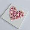 Canvas artwork featuring a heart embroidered with pearls, beads, metallic thread, and colorful alcohol ink accents.