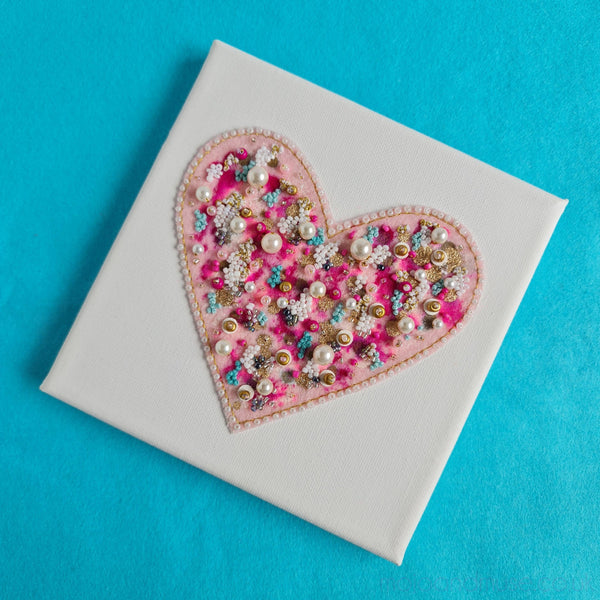 Embroidery and beads creating a pink heart with metallic thread on white canvas, part of Heart Series artwork.