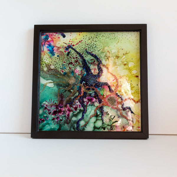 Abstract resin art inspired by starfish and rock pools, featuring embroidery and beading in a wooden frame.