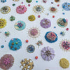 Close-up of colorful upcycled beads, sequins, and embroidery on canvas artwork titled Sea Jewels in the Snow 2021