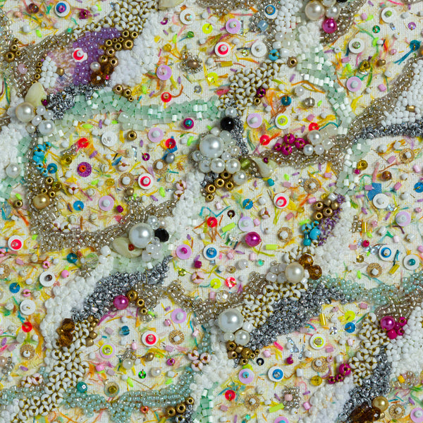 Close-up of intricate hand-embroidered canvas with beads, sequins, and colorful threads inspired by vibrant ocean sand.