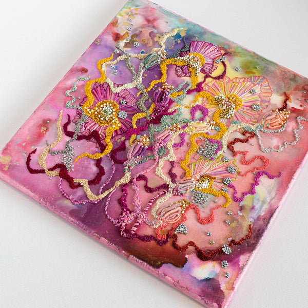 Abstract floral artwork with alcohol ink, hand embroidery, seed beads and metallic threads on 12 inch canvas.