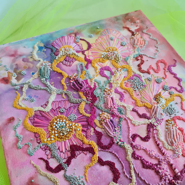 Abstract alcohol ink artwork with hand-embroidered yarns, seed beads, and metallic threads on canvas.