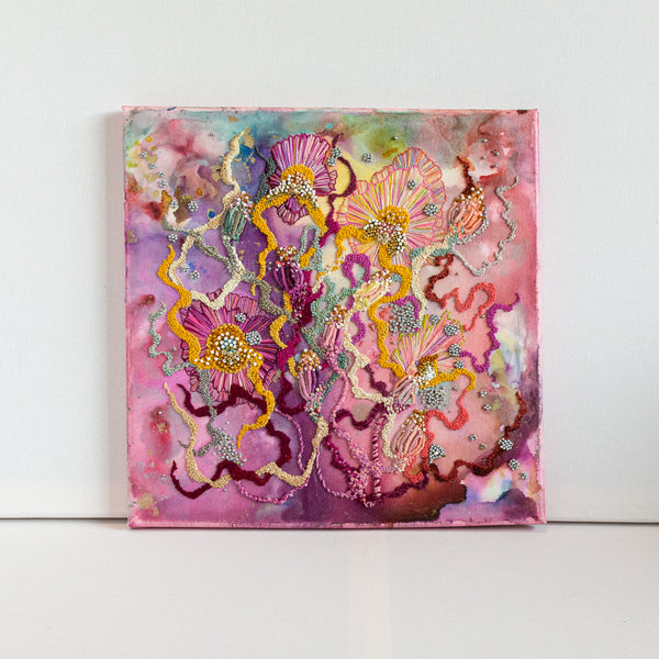 Abstract alcohol ink painting with hand-embroidered threads, seed beads, and metallic details on canvas, 12 by 12 inches.