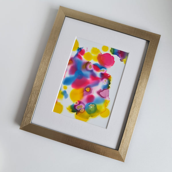 Abstract colorful alcohol ink artwork in a gold frame with white mount, titled Warhol Two, 2018, vibrant hues on Yupo paper.