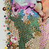 Close-up of colorful alcohol ink artwork with hand-embroidered beads, sequins, and gold threads on canvas.